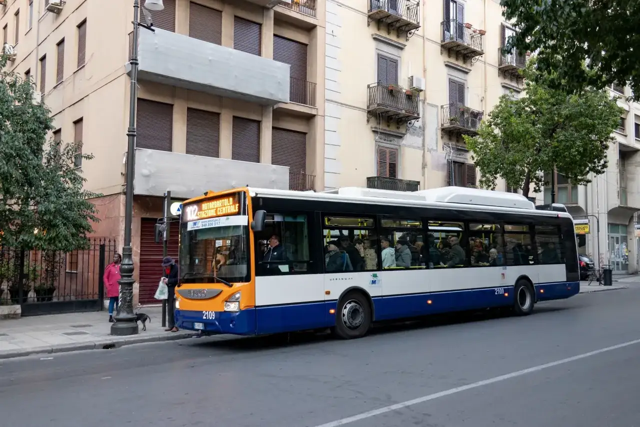Autobus linii 102 na Sycylii, część komunikacji miejskiej, z pasażerami w środku.