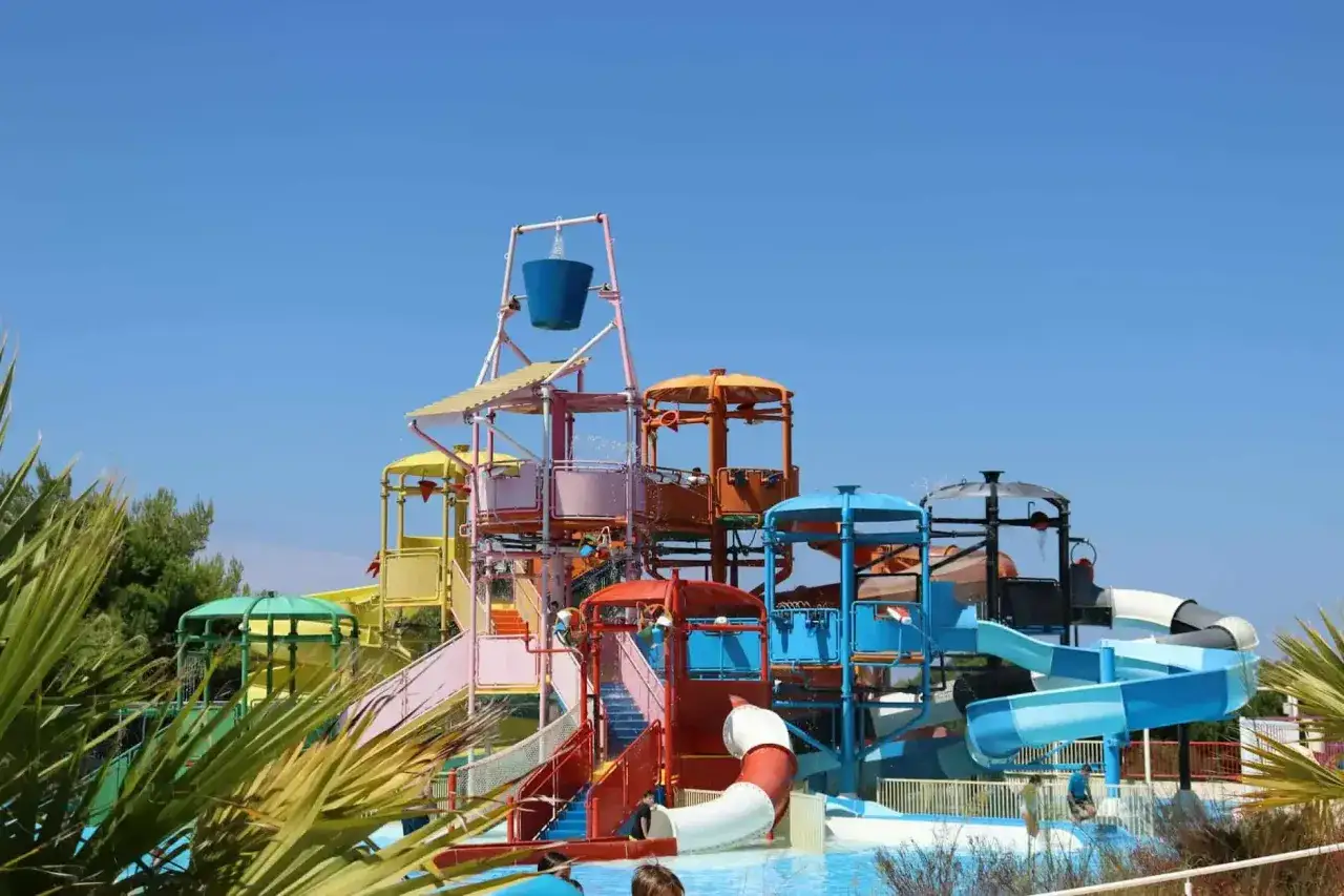 Kolorowy aquapark na Złotym Brzegu w Bułgarii, z mnóstwem zjeżdżalni i atrakcji wodnych, zaprasza do zabawy pod błękitnym niebem.