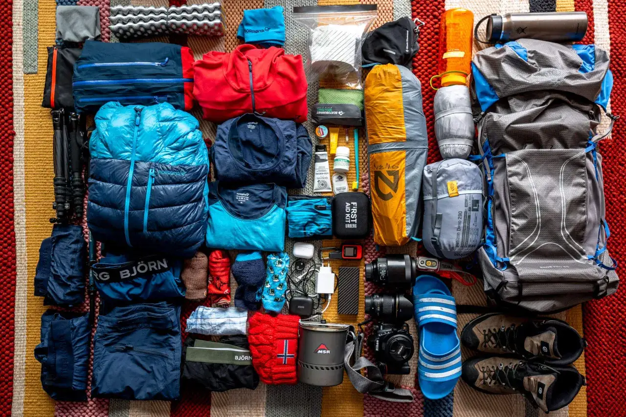 Pakowanie do Norwegii: ciepłe ubrania, śpiw&oacute;r, plecak, buty trekkingowe, termos, apteczka i sprzęt fotograficzny.