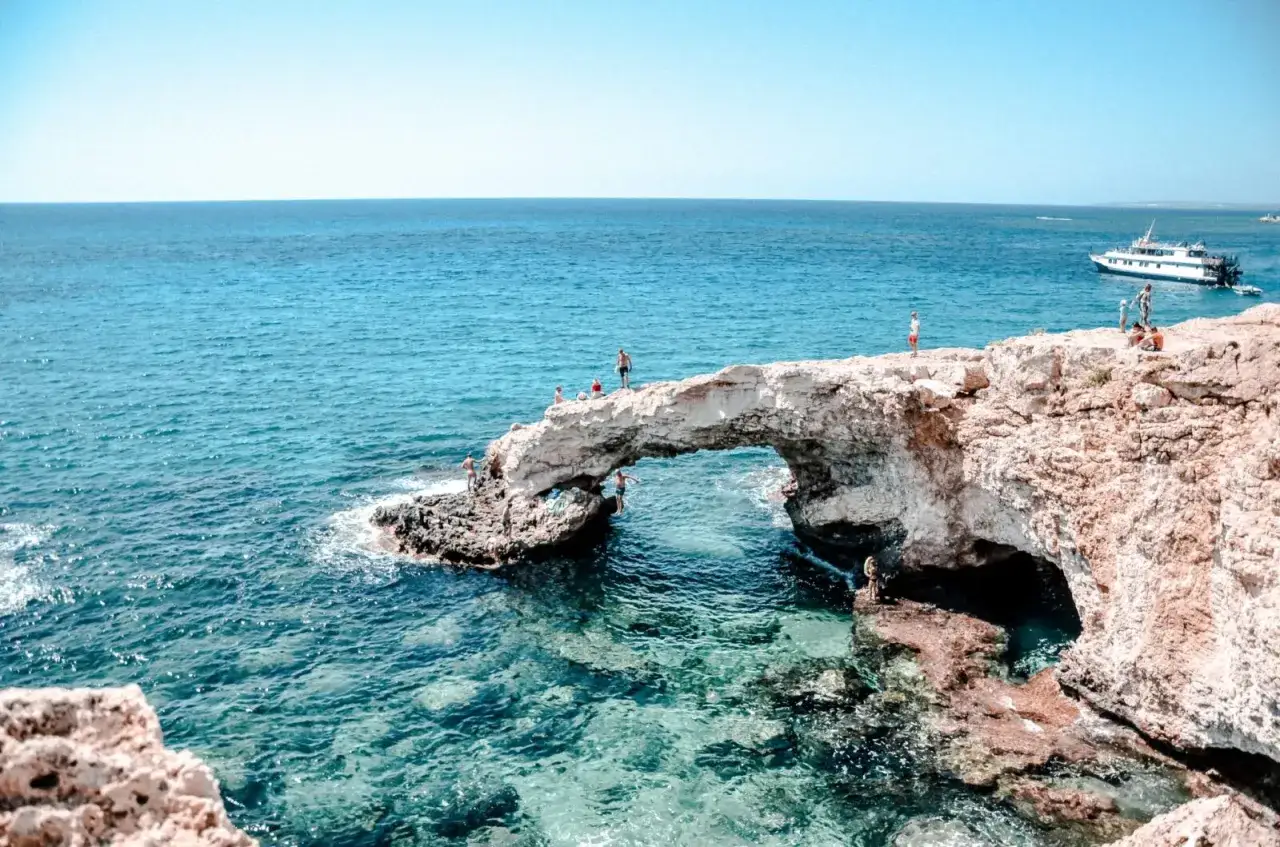 Kamienny most w Ayia Napa, gdzie turyści podziwiają turkusowe morze i skaczą do wody. Jedna z gł&oacute;wnych atrakcji Ayia Napa.